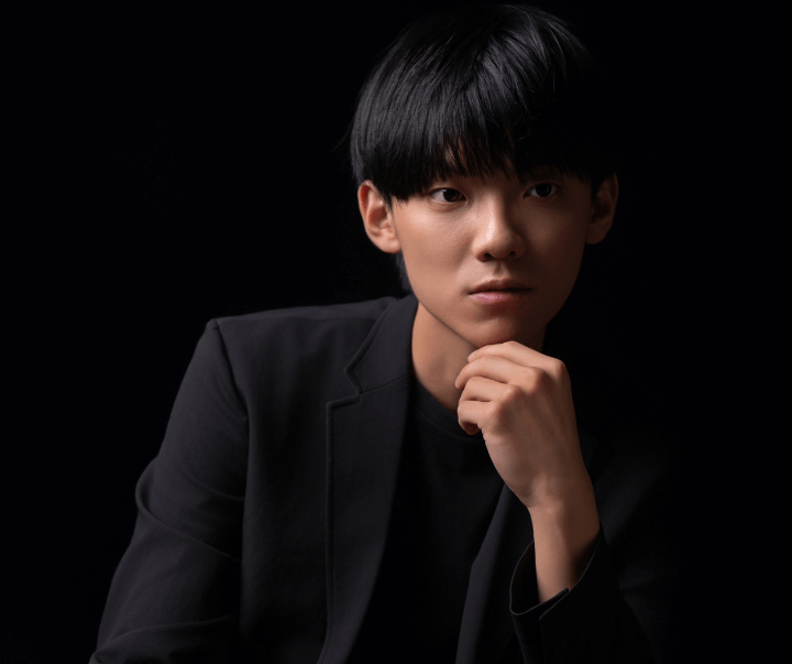 Miao Gao poses with his hand on his chin.